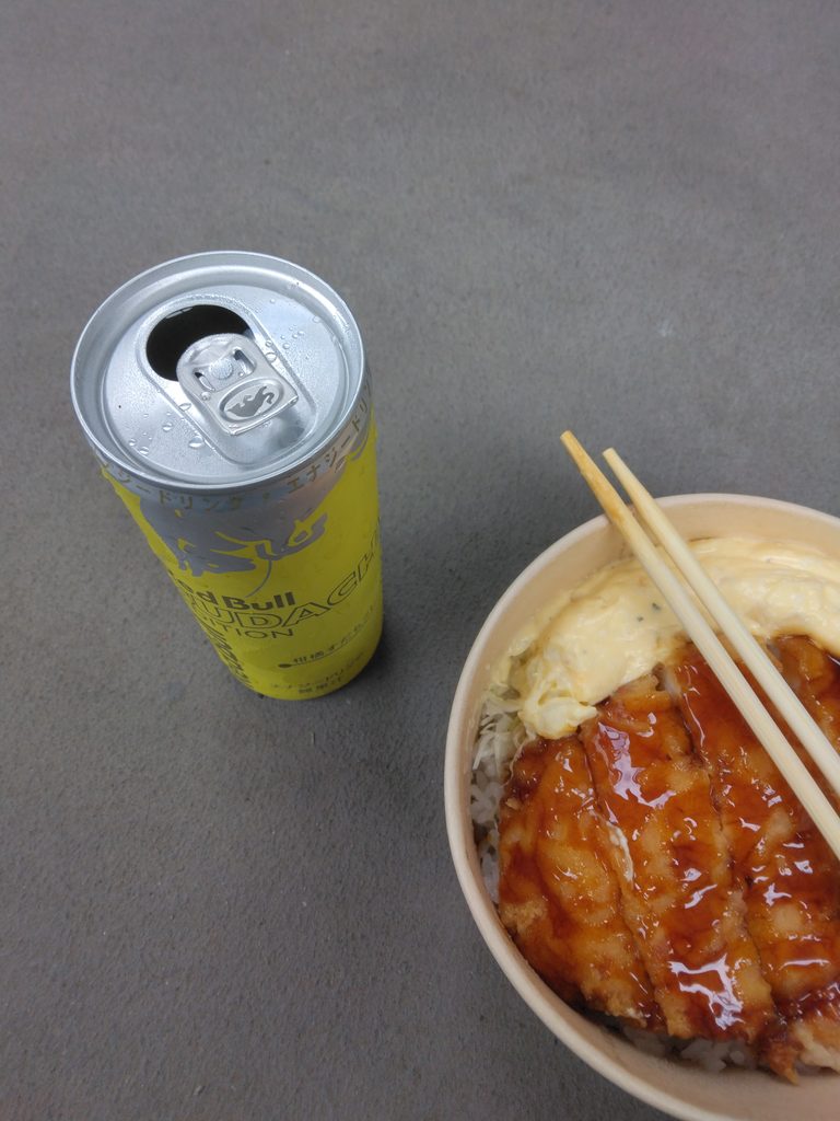 お弁当と缶を開けたレッドブルすだちエディション